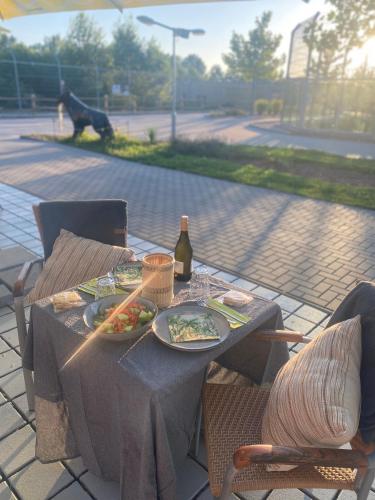 a table with plates of food and a bottle of wine at Malkia Penzion in Orechová Potôň