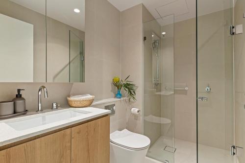 a bathroom with a toilet and a glass shower at Zi apartments - with Balcony, Bayview, Sauna and Pool in Melbourne