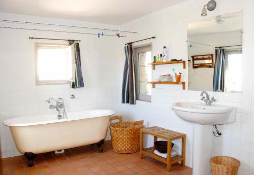 une salle de bain avec une baignoire blanche et un lavabo dans l'établissement Les Tourelles, à Uzès