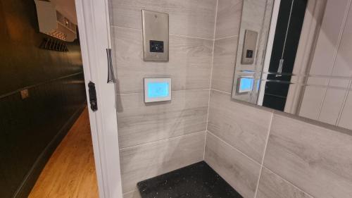 a bathroom with a walk in shower with a mirror at Bijou Malthouse in Alcester