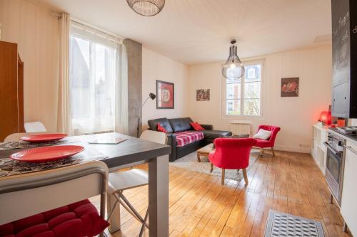 uma sala de estar com um sofá e uma mesa em "AU VINCI ROUGE" Downtown - Modern - Bright em Amboise