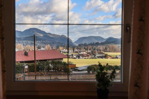 a window with a view of a town and mountains at Ferienwohnung Söldenköpfl-Blick in Schönau am Königssee