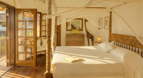 a bedroom with a bed with a book on it at Kobe Suite Resort in Watamu
