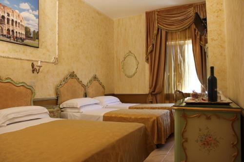 a hotel room with three beds and a window at Hotel Romulus in Rome