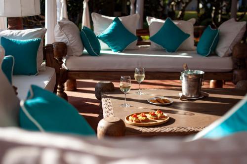 a table with a plate of food and two glasses of wine at Kobe Suite Resort in Watamu