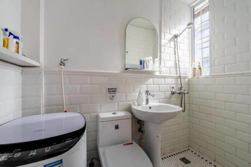 uma casa de banho branca com um WC e um lavatório em Shanghai Downtown Flower B&B em Xangai