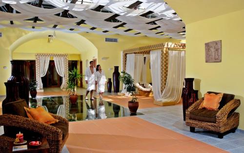 two people are standing in a living room at Sol Nessebar Mare All Inclusive in Nesebar