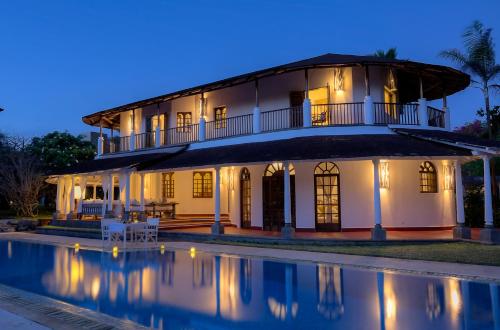 a villa with a swimming pool at night at Kobe Suite Resort in Watamu