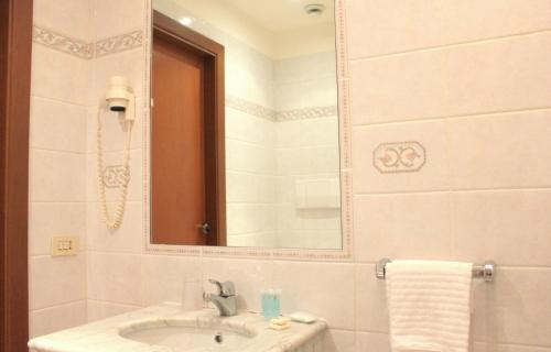 bagno con lavandino e specchio di Hotel Romulus a Roma
