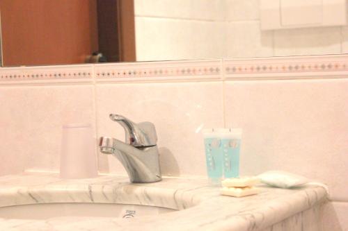a bathroom sink with a faucet and a toothbrush at Hotel Romulus in Rome