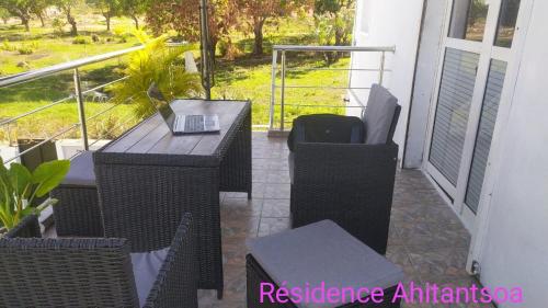 a balcony with a table and chairs on a porch at Résidence Ahitantsoa Appartement à l'étage in Mahajanga