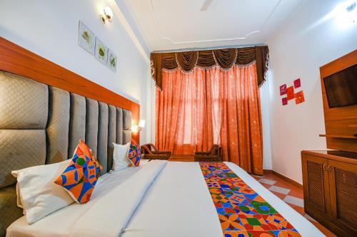 a bedroom with a large bed and a television at FabHotel Prime Hemkunth in Kasauli