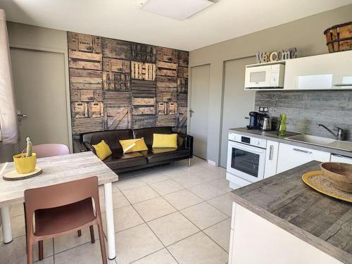 a kitchen and living room with a couch in the background at Condrieu, le Châtillon au cœur du vignoble belle vue sur vallée du Rhône in Condrieu
