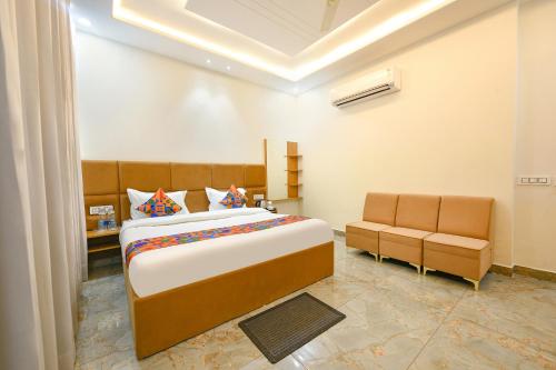 um quarto com uma cama grande e 2 cadeiras em FabHotel Flying Kiwi em Mohali