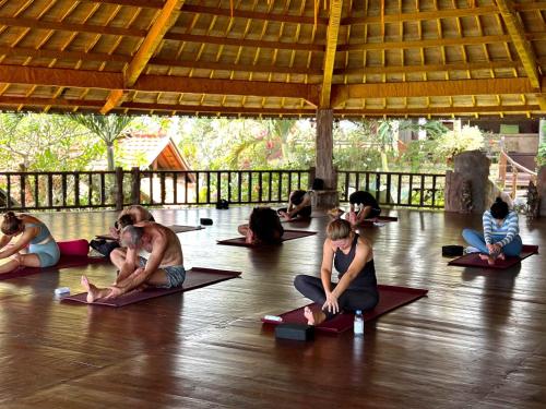 - un groupe de personnes assises sur le sol pour faire du yoga dans l'établissement Udara Bali Yoga Detox & Spa, à Canggu