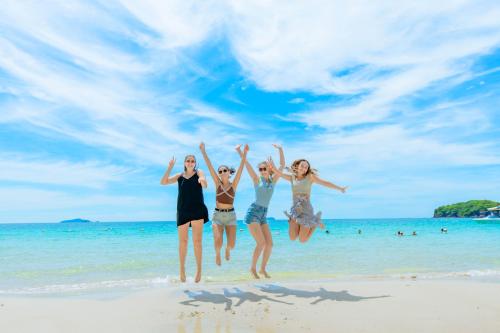 a group of girls jumping on the beach at Sea Sunset Hotel Phu Quoc - Welcome to a mixing world of friends in Phu Quoc