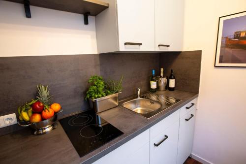 a kitchen with a sink and a bowl of fruit at Ferienwohnungen in der Altstadt Stralsund in Stralsund