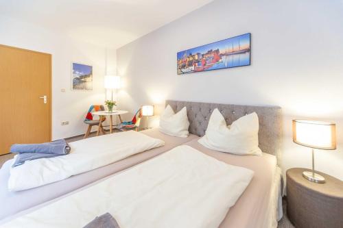 a hotel room with two beds with white sheets at Ferienwohnungen in der Altstadt Stralsund in Stralsund