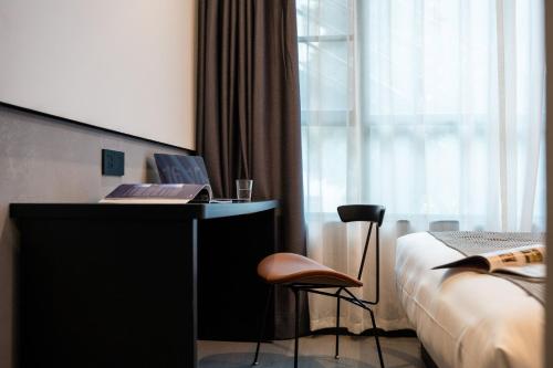a hotel room with a desk with a laptop and a chair at Banana Fun Hotel - Guangzhou East Railway Station Yantang Metro Station in Guangzhou