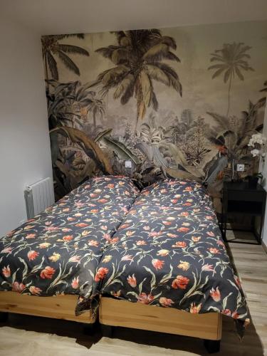 un letto con piumone floreale in una camera da letto di Villa Chêne Vert Wifi Clim Parking privé a Les Angles Gard