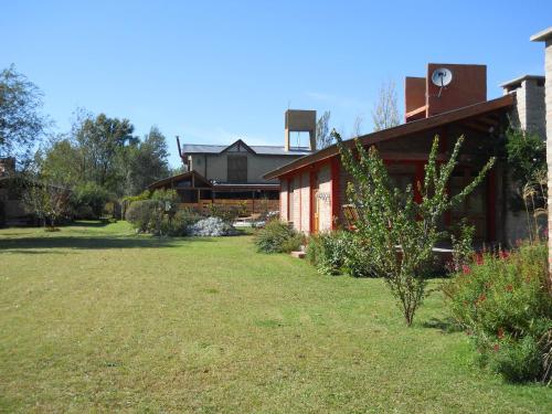 a house with a yard in front of it at Cabañas El Quijote in Los Reartes