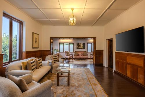 a living room with couches and a flat screen tv at Gateway Coonoor in Coonoor