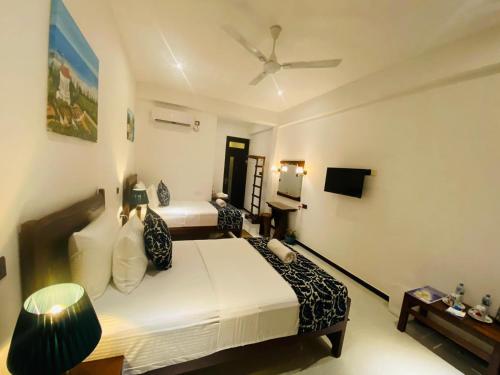 a bedroom with a bed and a ceiling fan at Airport Faith Hotel in Katunayake