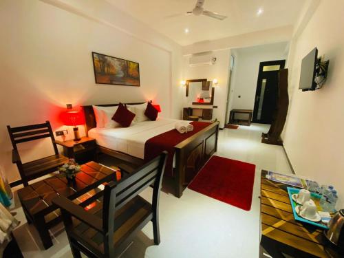 a bedroom with a bed and a living room at Airport Faith Hotel in Katunayake