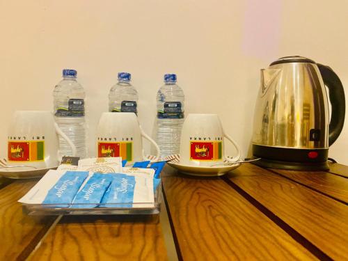 a wooden table with bottles of water and a kettle at Airport Faith Hotel in Katunayake