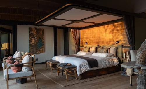 una camera con un grande letto e due sedie di Euphorbia Mashatu a Lentswelemoriti