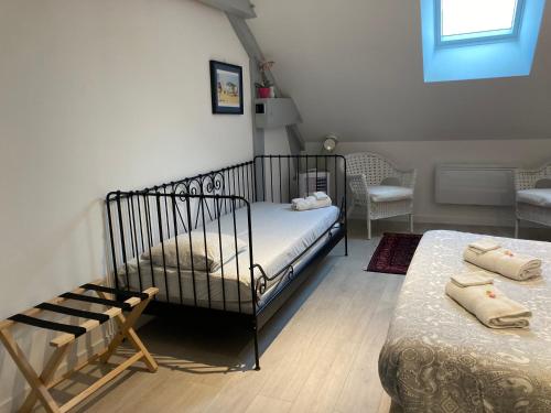 1 dormitorio con cuna, cama y silla en Chambres d'hotes Maison Gille, en Nuits-Saint-Georges