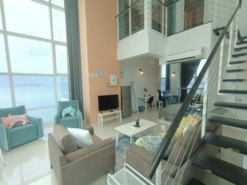 sala de estar con 2 sillas y escalera en Maritime Suite @ George town by Cohans, en Jelutong