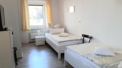 a small room with two beds and a window at Ferienwohnung Oberschieda in Kirchenlamitz