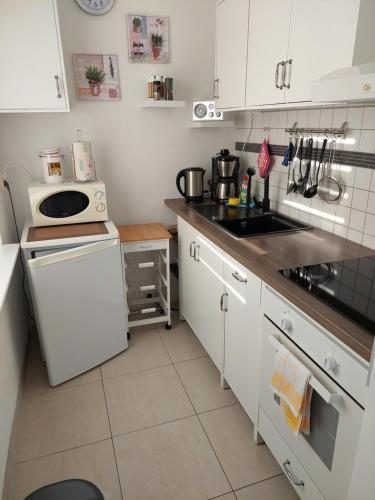 a kitchen with white cabinets and a stove top oven at Wohlfühlort in Zwenkau