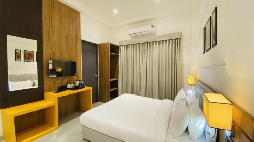 a hotel room with a white bed and a television at The Shankara View in Godarpura