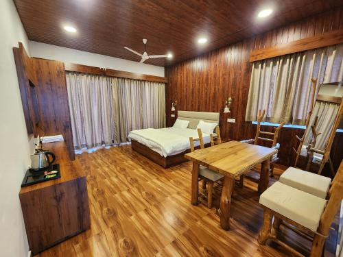 Zimmer mit einem Bett, einem Tisch und einem Bett sowie einem Tisch und Stühlen in der Unterkunft Empyrean Lake Resort in Balod