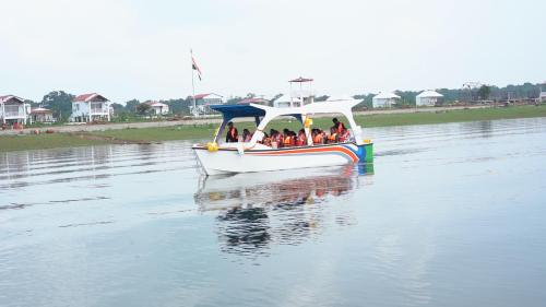 een groep mensen in een boot op een rivier bij Empyrean Lake Resort in Balod