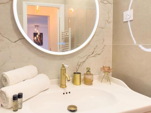 une salle de bain avec un lavabo et un miroir dans l'établissement Le Doré by Winsome Destination, à Cannes
