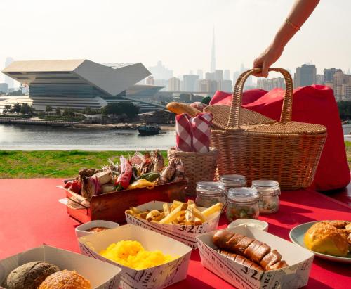 ドバイにあるCrowne Plaza Dubai Festival Cityの赤いテーブル布の上に食べ物のバスケットを入れたテーブル