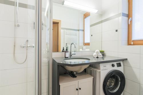 a bathroom with a sink and a washing machine at ALPSTAY Platzhirsch - Ski-In & Ski-Out in Bad Kleinkirchheim
