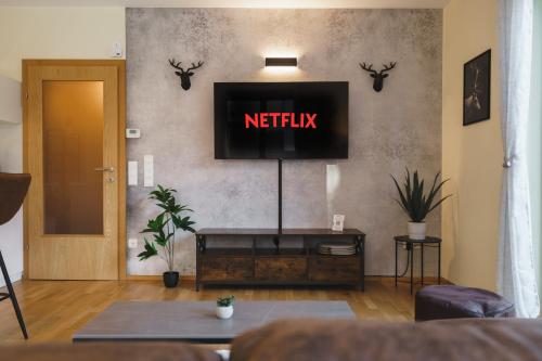 a living room with a tv with the words netflix at ALPSTAY "Platzhirsch" - XL Garten, Gondelnähe & Netflix in Bad Kleinkirchheim