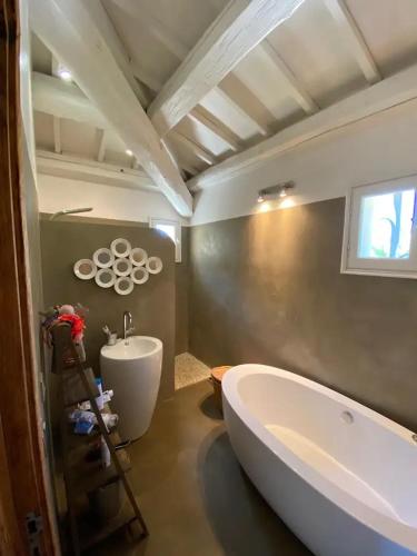 une salle de bain avec une baignoire et un lavabo et une baignoire dans l'établissement Mas Carpe Diem Contemporain classée 3 étoiles -Piscine-A 400 m de la mer, à Carry-le-Rouet