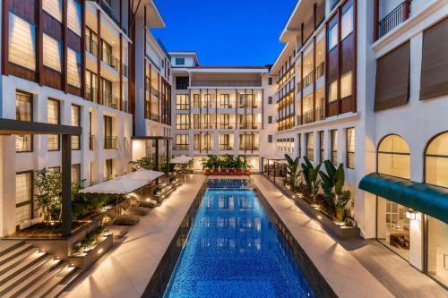 uma piscina interior no meio de um edifício em The Astor - All Suites Hotel Candolim Goa em Candolim