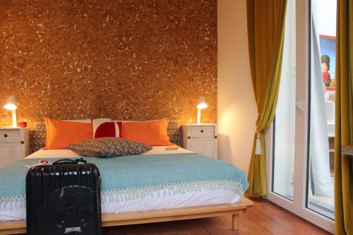 a bedroom with a bed with orange pillows and a suitcase at Villa Kumquats in Béziers