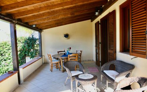 un patio con tavolo e sedie sul balcone. di Azzurro Mare - Cornino a Custonaci