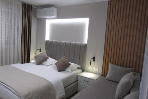 a bedroom with a white bed and a window at Freddy's Hotel in Tirana