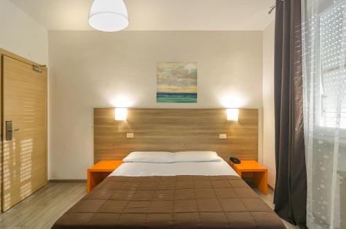 a bedroom with a large bed and two tables at Hotel Capitol in Pisa