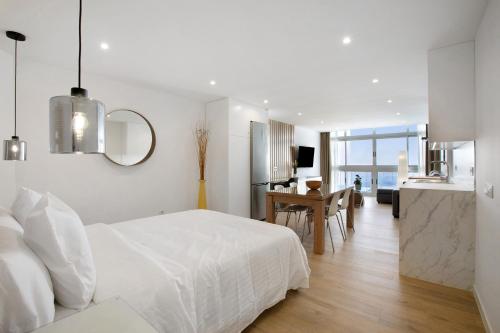 1 dormitorio blanco con 1 cama blanca y cocina en Luxury Loft Mar y Sol 1 en Tacoronte