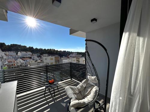 a balcony with a chair and a view of a city at Sandi Hvar Apartments in Hvar