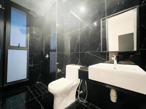 y baño con aseo blanco y lavamanos. en Urban Suites by PerfectSweetHome with Spectacular High View# Komtar View, en Jelutong